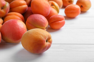 Delicious fresh ripe apricots on white wooden table