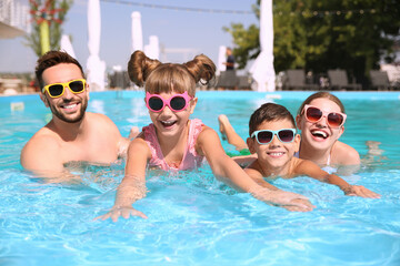 Happy family having fun in swimming pool