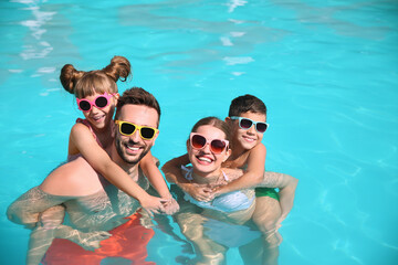 Happy family in swimming pool on sunny day