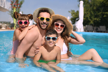Obraz na płótnie Canvas Happy family in swimming pool on sunny day