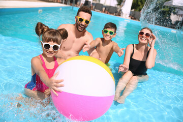 Happy family having fun in swimming pool