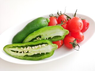 お皿の上にある野菜/ピーマンとトマト