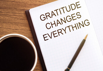 Gratitude changes everything - written in a notebook with a cup of espresso coffee and a pen