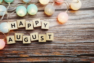 Happy August alphabet letter with LED Cotton ball Decoration on wooden background