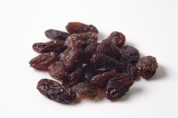 Black dried raisins on a white background