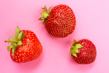 Fresh red strawberries on pink background. Close up photo.