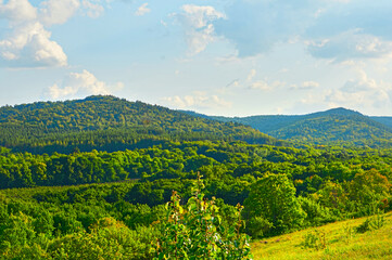 Obraz premium Beautiful fields against the backdrop of mountains and blue sky with clouds.