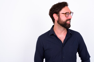 Fototapeta premium Portrait of happy handsome bearded businessman against white background