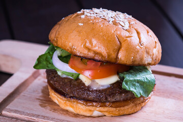 delicious angus beef burger with lettuce, tomato, cheese, and onion