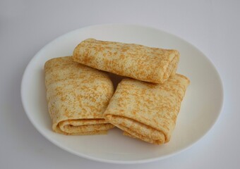 Baked spring rolls wrapped in an envelope on a white plate