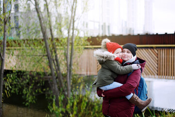 Young pretty mother holding and hugging her cute little preschooler daughter and smiling