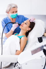 Fototapeta premium Woman receiving innovative procedure of cryoliposuction in clinic of esthetic cosmetology