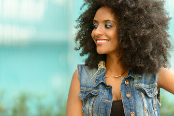 Happy young beautiful African woman with Afro hair in the city