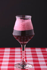 Glass of cold drink with strawberries on a dark black background, isolated, close-up.