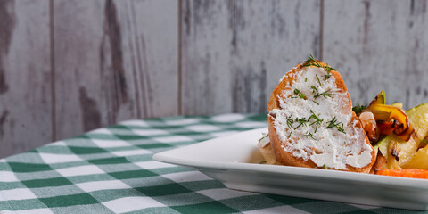 Bruschetta with cream cheese and fresh dill. Traditional Italian dish, tasty meal. Fried potatoes with vegetables.