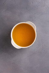 Bouillon in bowl on gray surface with copy space