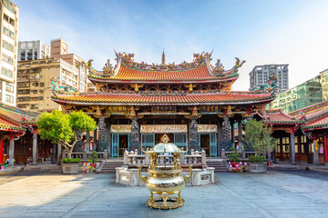 Obraz premium Świątynia Lungshan w Tajpej na Tajwanie. Chiński tekst brzmi: „Chroń lud”, „Łaska i płodność” oraz „Łaska oświetla wszystkie stworzenia”. Chiński tekst na kadzielnicy brzmi „Budda Guanyin”.