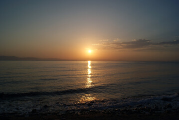Beautiful dawn over the sea. Sunny path on the water. Light wave and swell on the surface of the water