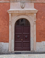 vintage house entrance natural wood door and white arched frame, Rome Italy