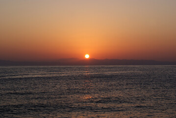 Beautiful dawn over the sea. Sunny path on the water. Light wave and swell on the surface of the water