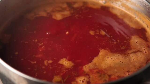 red soup borsch cooking in a pot. Cooking homemade food. Traditional Ukrainian Russian dish