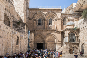 Naklejka premium Numerous tourists stand at the entrance to the Holy Sepulchre in the Old City in Jerusalem, Israel