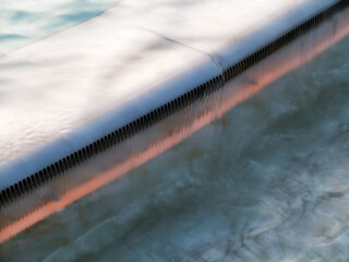 Clear and clean water in pool background. Waves on blurred surface.