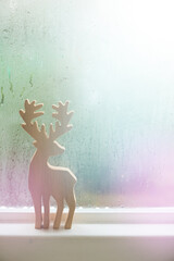Raindrops on window glass and deer sculpture wood background.