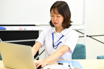 ノートパソコンを操作する医療従事者