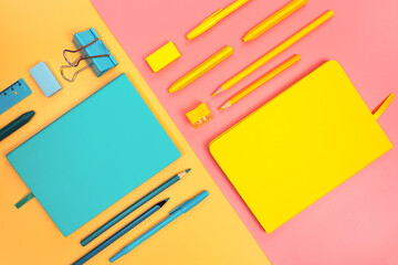 Back to school minimal concept bright pastel colors. Double paper background. Diagonal composition. Turquoise teal color stationery. Yellow objects. Peach and millennial pink backgrounds.