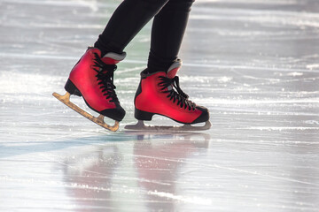 feet in red skates on an ice rink. hobbies and leisure. winter sports