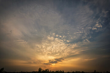Sunset sky in evening.Clouds covering the sun in the lower middle of frame and golden light on clouds.