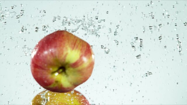 Super slow motion of whole apples hitting in the air with water splashes. Filmed on high speed cinema camera, 1000 fps.