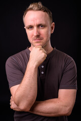 Handsome man with blonde hair against black background