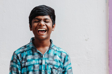 Portrait of an Indian kid laughing while staring at the camera	