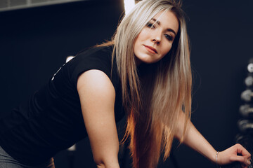 Portrait of a young woman in sportswear posing in a gym