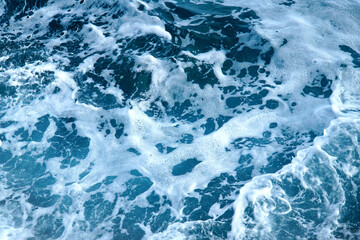 Fototapeta na wymiar View of blue sea water with waves and white foam.