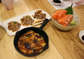 Raw Salmon sashimi on ice and bowl and wood desk