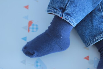 Foot of small baby in a wooden cot.