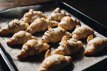 Freshly baked homemade croissants on wooden table, selective focus Fresh out of the oven. Breakfast or brunch concept.