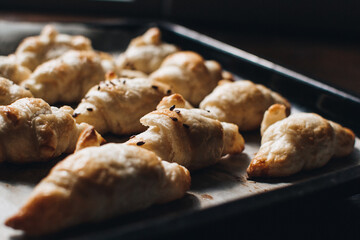 Freshly baked homemade croissants on wooden table, selective focus Fresh out of the oven. Breakfast or brunch concept.