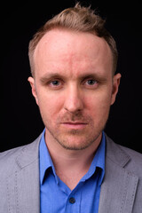 Fototapeta premium Handsome businessman with blonde hair against black background