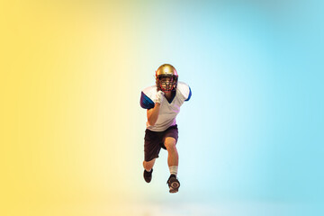 Fototapeta premium Unstoppable. American football player isolated on gradient studio background in neon light. Professional sportsman during game playing in action and motion. Concept of sport, movement, achievements.