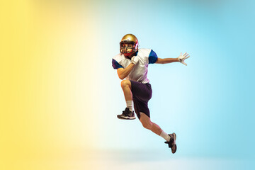 Fototapeta na wymiar Catching. American football player isolated on gradient studio background in neon light. Professional sportsman during game playing in action and motion. Concept of sport, movement, achievements.
