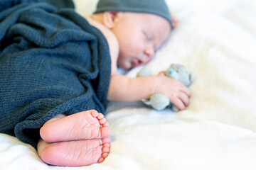 newborn baby sleeping in the arms of a toy