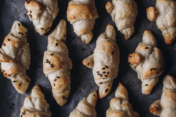 Freshly baked homemade croissants on wooden table, selective focus Fresh out of the oven. Breakfast or brunch concept.