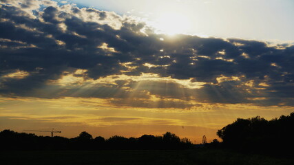 Fototapeta premium sun rays from clouds in the evening field