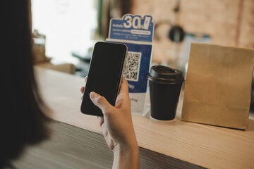 woman customer using digital mobile phone scan QR code pay for buying coffee in modern cafe coffee shop, cafe restaurant, digital payment, online shopping, takeaway food, internet technology concept