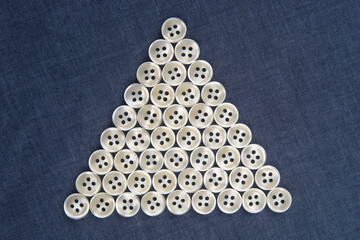 Plastic shiny buttons for clothes on a fabric background. Fashion and clothing. Factory industry.