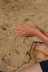 Hand clasping golden sand falling through the finger, with place for text
